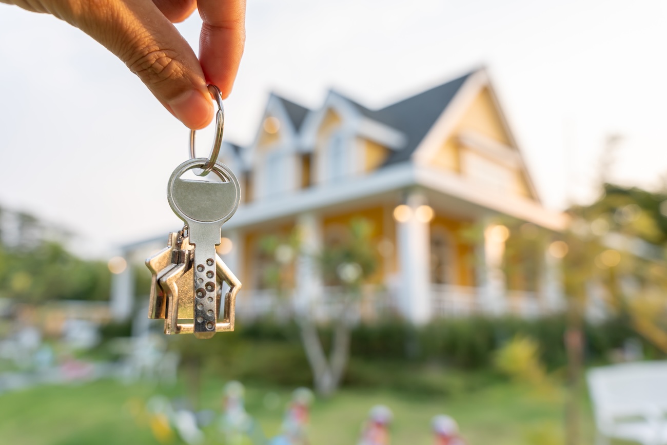 keys dangling in front of sold home